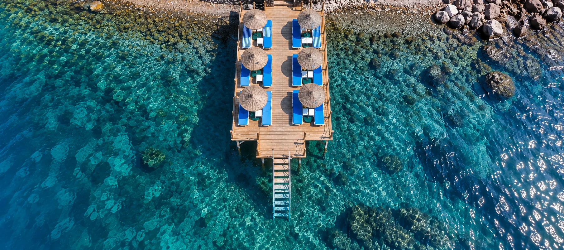 Assos Livia Otel'in iskelesi, şezlongları ve turkuaz deniz, havadan görünüm